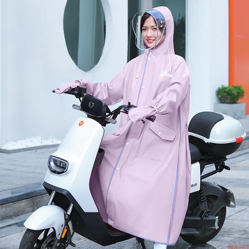 Female rider wearing waterproof motorcycle raincoat on scooter